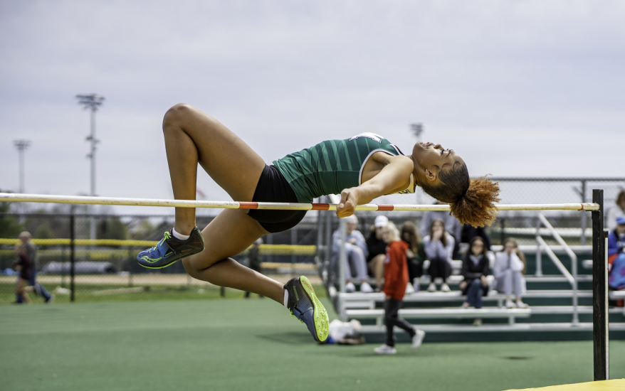 girl jumping over pole